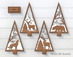 three wooden christmas trees with deer and snowflakes on them, mounted to the wall