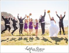 a group of people jumping in the air with their hands up and one person wearing a purple dress