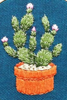 an embroidered cactus in a pot with pink flowers