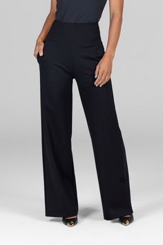 A woman is standing with one hand in her pocket, wearing black high-waist, wide-leg ponte pants. The waistband is thick and structured, emphasizing the high-rise fit, while the wide-leg design offers a loose, comfortable silhouette. The fabric appears soft and slightly stretchy. Chic Wide-leg Yoga Pants, Black Yoga Pants With 4-way Stretch, Versatile Full-length Elastane Yoga Pants, Versatile Straight Leg Yoga Pants, Chic Elastane Sweatpants For Loungewear, Black Yoga Pants With Minimal Stretch, Black Pants With Minimal Stretch For Yoga, Elegant Wide-leg Sweatpants With Elastic Waistband, Elegant Wide Leg Sweatpants