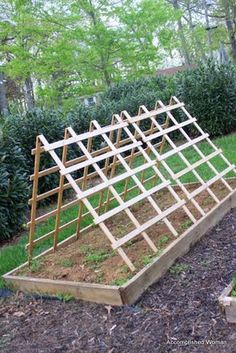 a wooden structure sitting in the middle of a garden