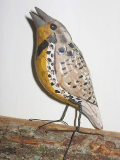 a painted bird sitting on top of a tree branch