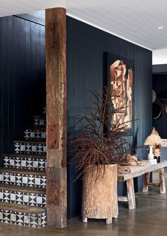 a wooden table sitting next to a set of stairs in a room with blue walls