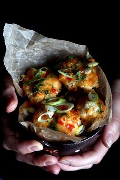 a hand holding a bowl filled with food