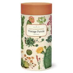 an orange and white canister filled with various types of flowers, plants and cacti