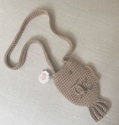 a crocheted bag with a cat on the front and a tag attached to it