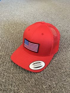 "This is a NEW United States of America Flag Embroidered Patch applied by hand to a high quality Yupoong or Richardson SnapBack trucker hat Yupoong Classic SnapBacks are 65% Polyester/35% Cotton, Structured, mid-profile, 3 1/2\" crown, six-panel Permacurv Visor adjustable plastic snapback closure 6 7/8\" to 7 1/2\" Richardson Hats are 60% cotton/40% polyester Structured, mid-profile, six-panel Pre-curved Visor adjustable plastic snapback closure 6 3/4\" -7 5/8\" Every Hat Design we offer is Crea Patriotic Snapback Hat With Flat Brim, American Style Adjustable Hat With Flat Brim, American Style Adjustable Flat Brim Hat, Trucker Baseball Cap With Curved Brim Made In Usa, Trucker Hat With Curved Brim Made In Usa, Adjustable Patriotic Hat With Flat Bill, Made In Usa Trucker Cap, Patriotic Red Adjustable Trucker Hat, Trucker Hat With Embroidered Patch Curved Brim