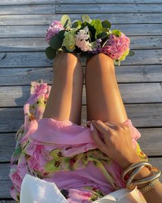 a woman laying on the ground with her legs crossed and flowers in her hair around her ankles