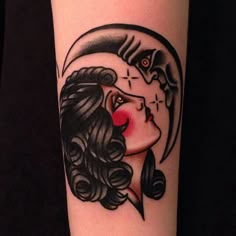 a woman's face with a crescent moon tattoo on her arm