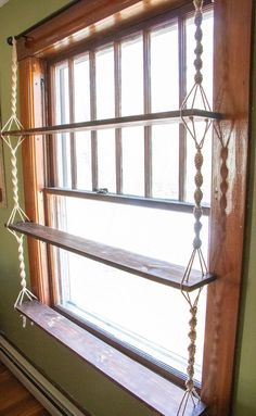 a window sill with three wooden shelves in front of it