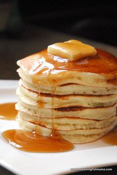 a stack of pancakes covered in syrup on a white plate with caramel drizzle