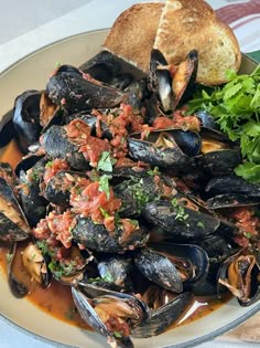 a plate full of mussels and bread on a table