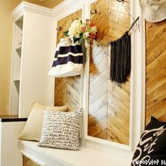 a room with wood paneled walls and decorative items on the wall, along with pillows