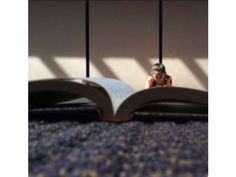 an open book sitting on top of a carpeted floor next to two black poles