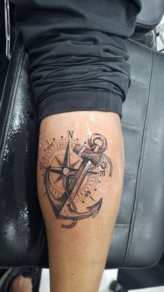 a person with a tattoo on their leg and an anchor in the middle of it