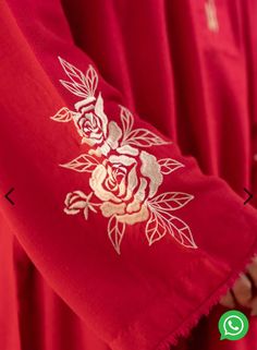 a person wearing a red robe with gold embroidered roses on the front and back side