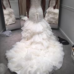 a woman in a wedding dress looking at herself in the mirror