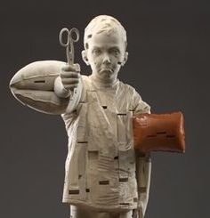 a statue of a man holding a football and scissors