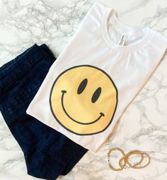 This timeless tee is such a perfect choice for any day! Featuring a retro happy face design on a white tee! This tee is such a cute casual look for casual days! The material is lightweight and soft - it's so comfortable to wear! Just pair with your favorite jeans and sunnies! It's also great for layering with a cozy sweater, a light jacket in Spring, or denim shorts and sandals in Summer! •Cotton & Polyester Blend •Materials may have natural variations •Colors may vary from different viewing Retro Smiley Face, Oversize Sleeves, Face Design, Cozy Sweater, Happy Face, Kpop Outfits, White Tee, Summer Cotton, Light Jacket