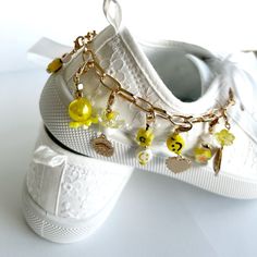 White satin-like shoelaces with detachable charm chain of yellow, white and gold beads.  Thread your new laces onto any pair of shoes and add your chain for an instant update!  Each charm is detachable so can be individually added directly onto the laces.   Wear your charm chain on your shoes, on a trucker cap or just as a charm bracelet! This listing includes one set of white shoelaces and one shoe charm chain with 12 detachable charms. Mix and match with our other charms, lace stars and butter Trendy Gold Sneakers With Laces, Charm Chain, Gold Charm Bracelet, Shoe Clips, Shoe Charms, Pink Silk, White Satin, Gold Charm, Gold Beads