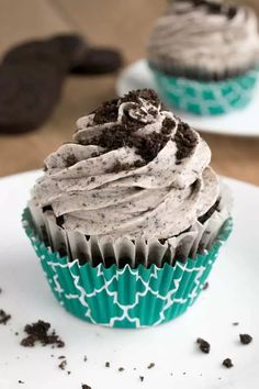 two cupcakes with chocolate frosting and oreo cookies on the top one