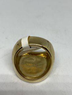 a gold and silver ring sitting on top of a white table