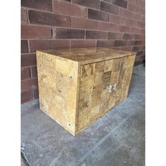 a large wooden box sitting in front of a brick wall