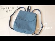 a small blue bag sitting on top of a white sheet with japanese writing in the background