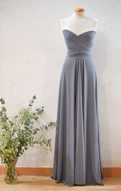 a dress on a mannequin next to a vase with flowers