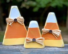 three small wooden cones with bows on them