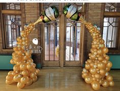 two champagne bottles on top of balloons in front of a doorway with the words balloon columns