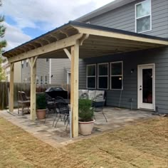 a patio covered in wood and surrounded by grass