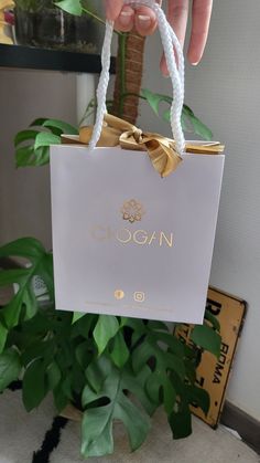 a person holding up a white bag with the word glogan written on it