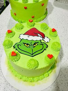 two cakes decorated with green frosting and the grin face on each one are sitting on a counter