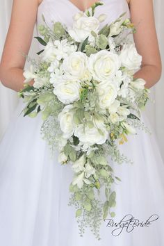 a bride holding a bouquet of white flowers