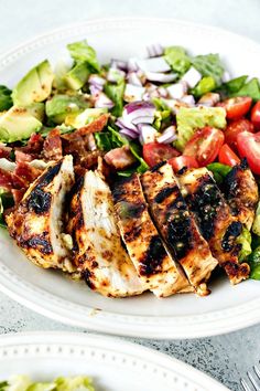 two white plates filled with chicken and salad