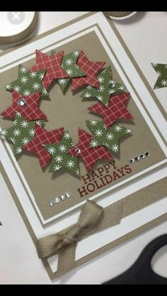 a close up of a christmas card on a table with scissors and other crafting supplies