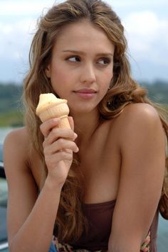 a woman holding a banana and looking at the camera