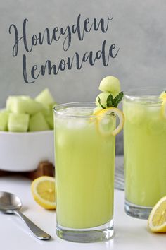 two glasses filled with lemonade sitting on top of a table