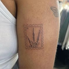 a woman's arm with a stamp on it that has a plant in it