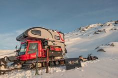 a truck is parked in the snow with a camper attached to it's back