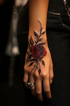 a woman's hand with a rose tattoo on it