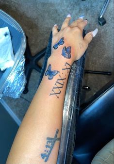 a woman's arm with butterflies on it and the word faith written in cursive writing