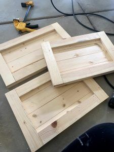 two wooden trays sitting on top of a floor next to a power cord and drill