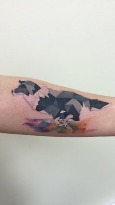 a bear tattoo on the right arm and left arm with watercolors in it