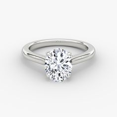 a round cut diamond engagement ring on a white background with the center stone in the middle