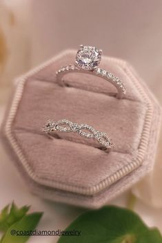 two wedding rings sitting on top of a velvet ring box