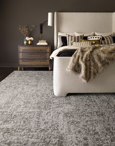 a bedroom with black walls, white bedding and an upholstered headboard