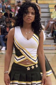 a woman in a cheerleader outfit standing on a basketball court