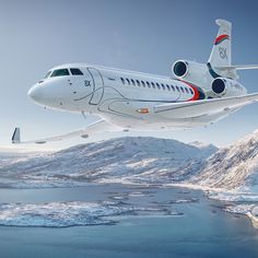 an airplane is flying over the water and snow covered mountains in the background, with ice floes on the ground